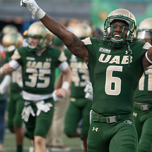 UAB football team celebrating on the field.