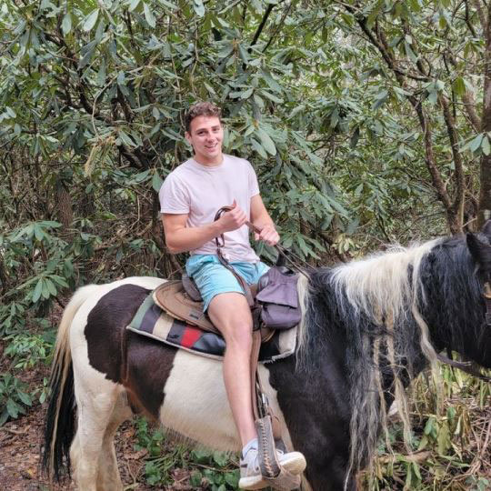 Diego Delany riding a black and white horse.