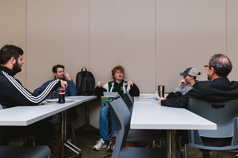 "Group of students hold a discussion with Jonathan Wiesen, Ph.D."
