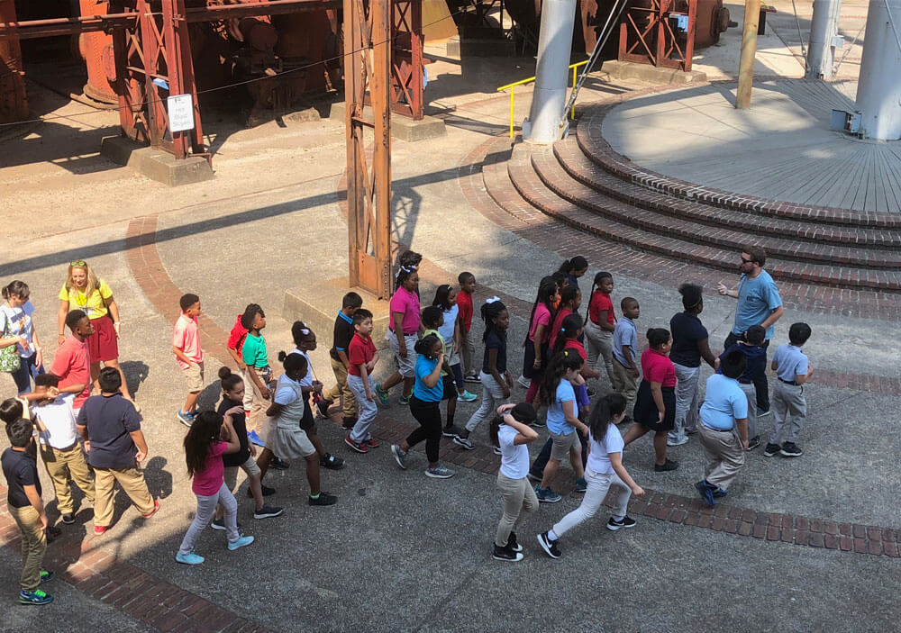 A History Department student guiding school children through Sloss Furnaces. 