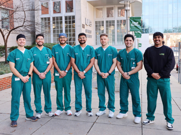 Digital Dentistry Club Officers (Left to Right: Ethan Brenna, Juan Serna, Savan Patel, Kamal Patel, Anton Poznyak, Ali Nazari, Rush Patel) standing in front of the School of Dentistry Building