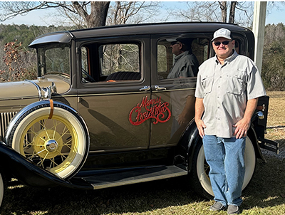 Man posing with antique car