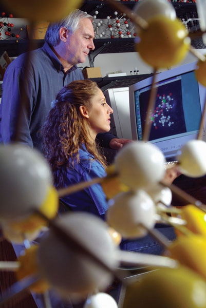 Professor and student looking at computer screen together.