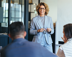 A female manager stands in front of her direct reports