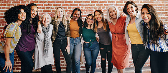 Cheerful diverse women standing in front of a red brick wall