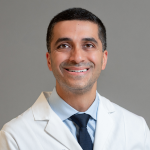 Professional man wearing a white doctor's coat and a blue shirt and tie
