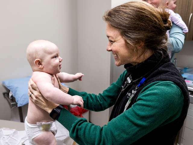 Doctor Erin DeLaney holds one Smith twin and smiles