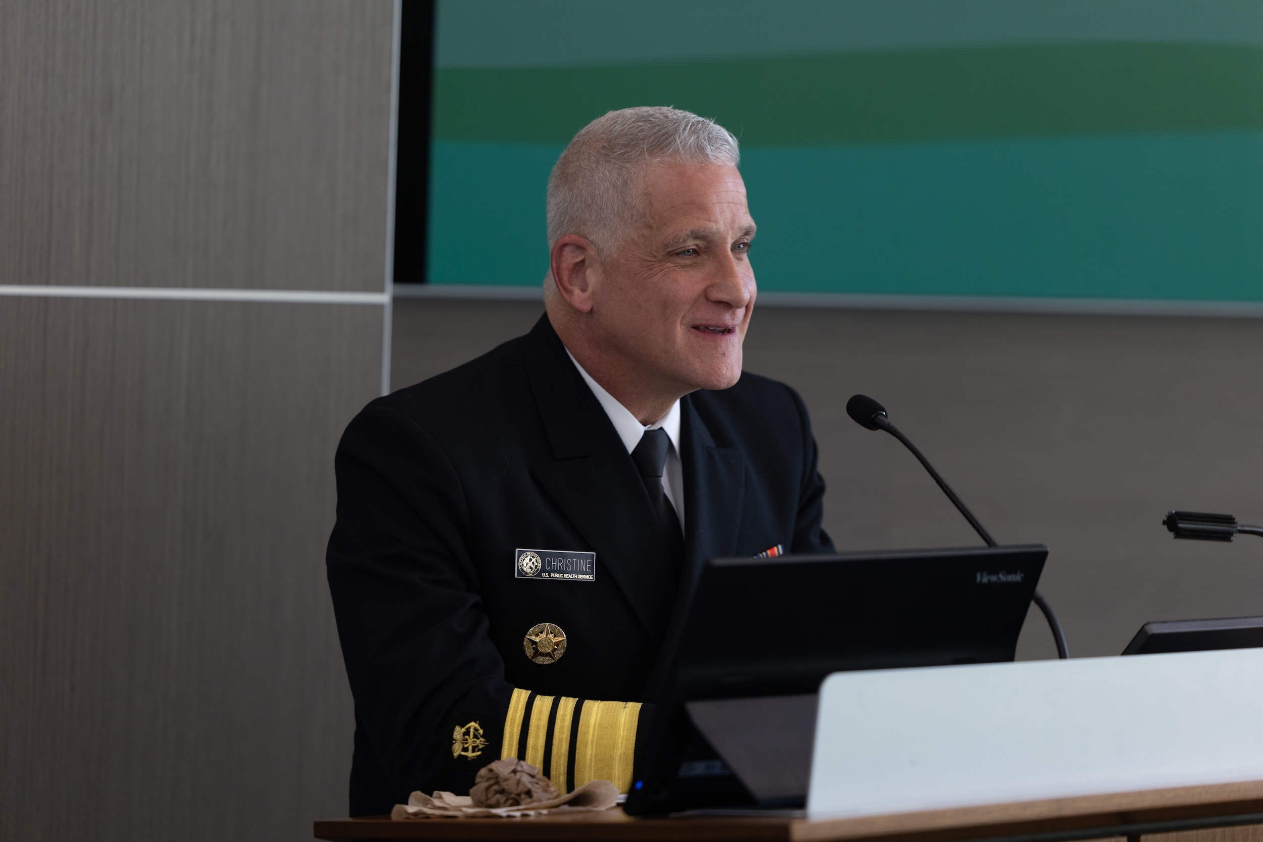 Admiral Brian Christine, M.D., speaking at a podium