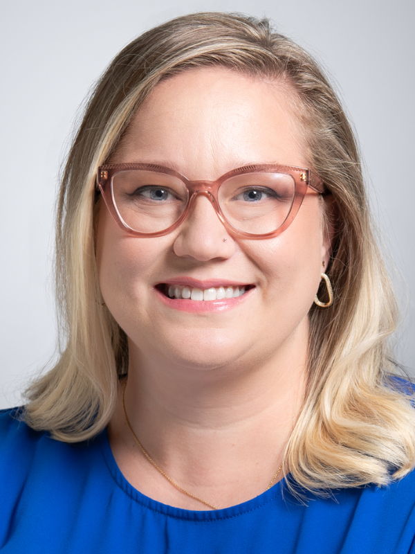 Olivia Van Gerwen, M.D., stands in front of a gray background.