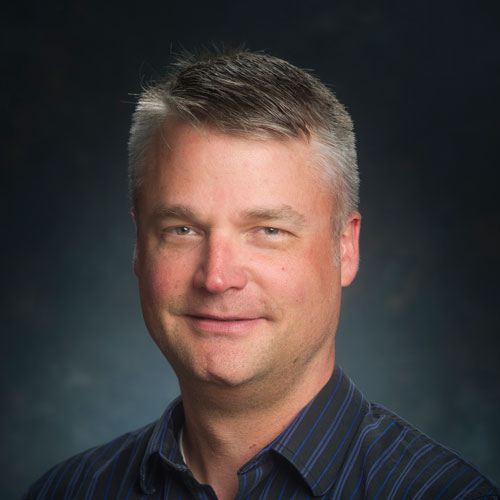 David Schneider head shot on a gray background