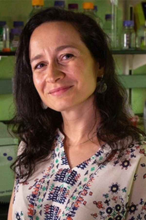 Ksenia Matlawska-Wasowska, Ph.D., stands in front of lab equipment.