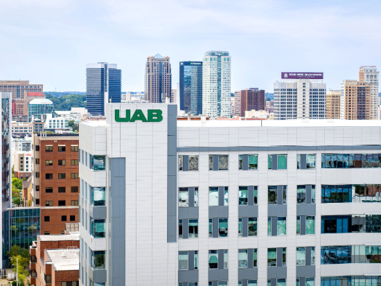 Drone photo of the UAB Rehabilitation Pavilion with other UAB medical campus buildings and the Birmingham skyline in the background.