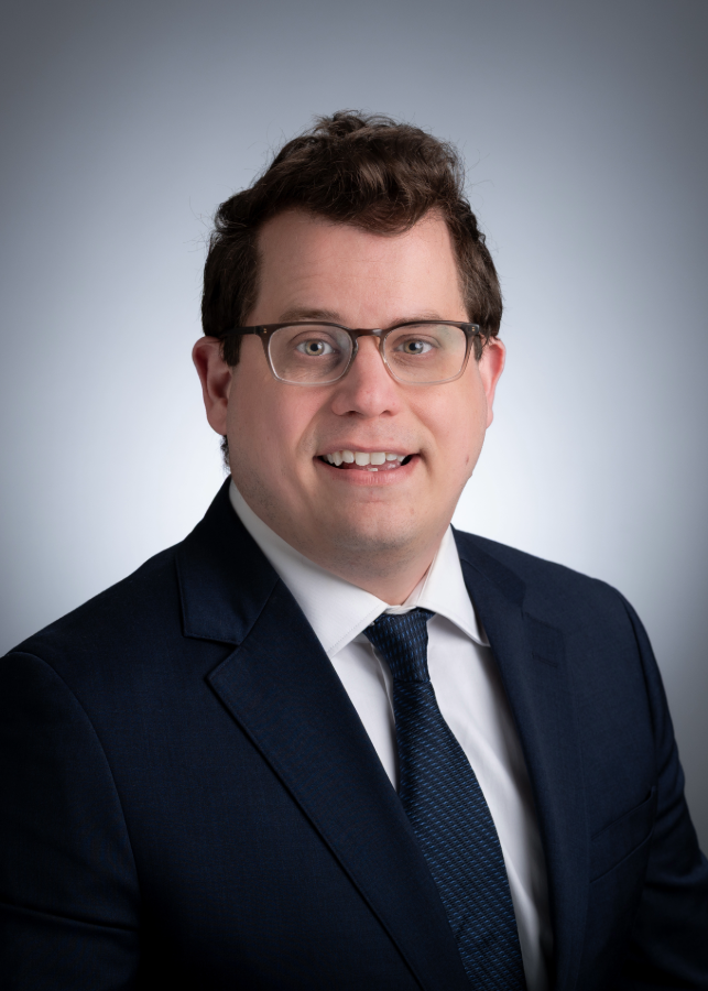 Headshot of Tylor Lewis, Ph.D., in front of a gray background.