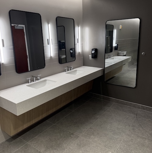 Restroom double sink with mirrors on wall above them.