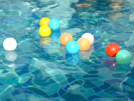 Floating colorful round items in a body of water.