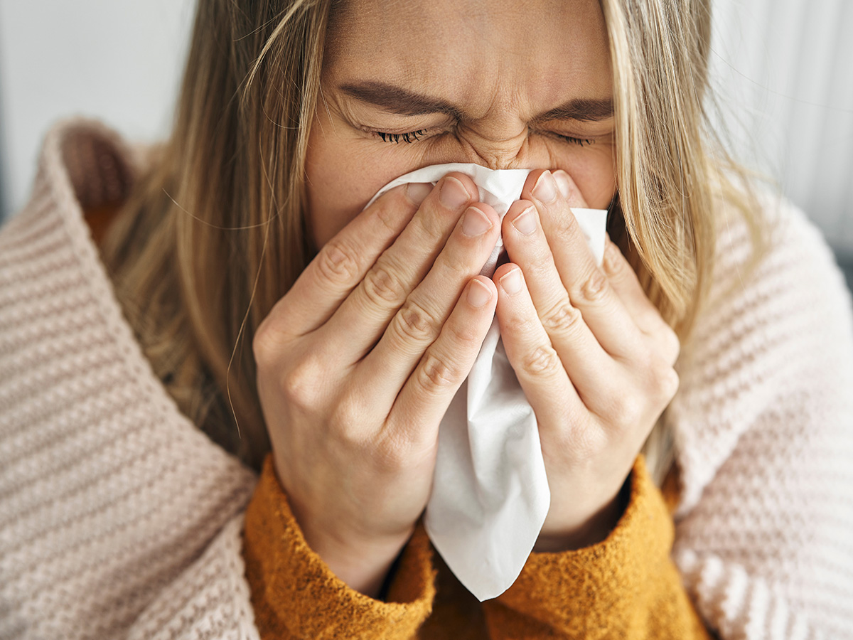 Woman blowing nose during flu