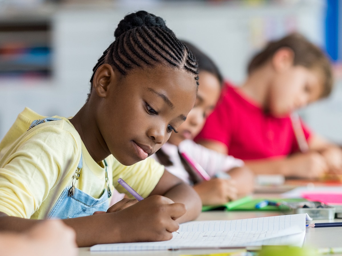 girl taking notes in a notebook in classroom