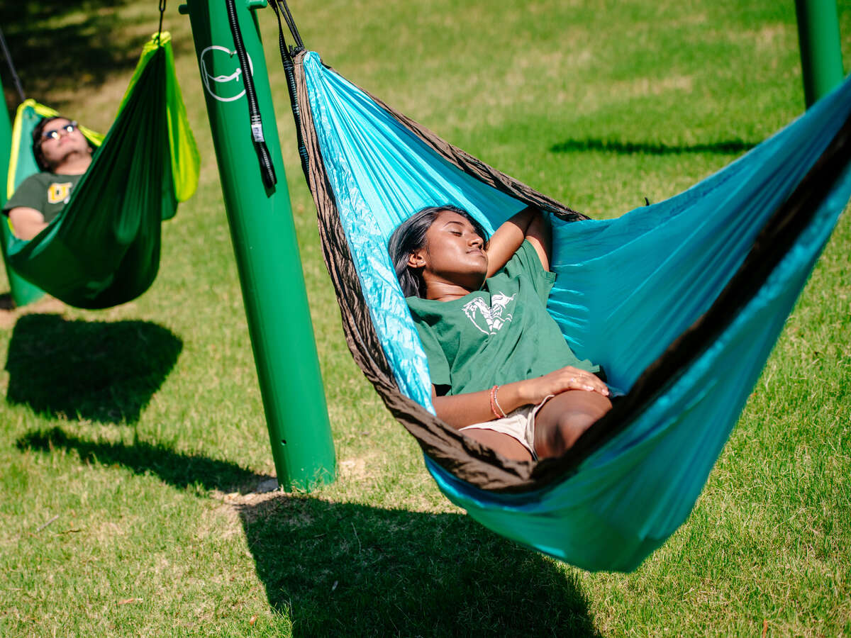 Rodolfo Guzman (Student, Biology) and an unidentified female student are laying in hammocks in the Hammock Park, June 2019.