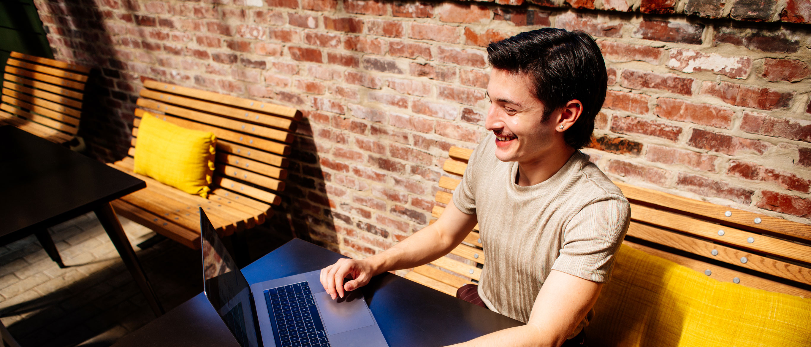 Ethan smiling while working on laptop outdoors