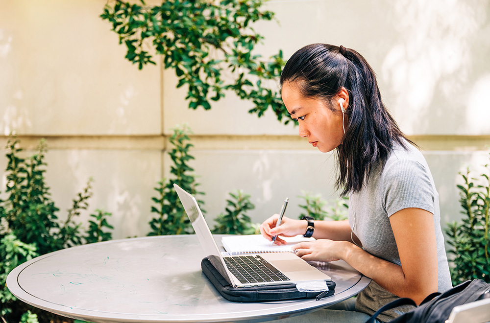 A student studies outside Heritage Hall