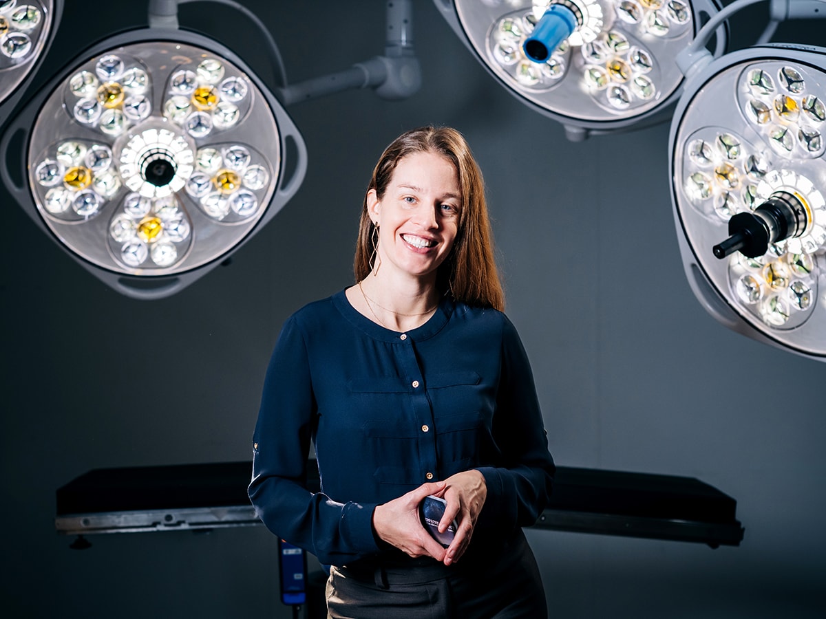 Kimberly Kopecky, M.D., holds a deck of cards from The Empathy Project, the game she created, while surrounded by surgical lights.