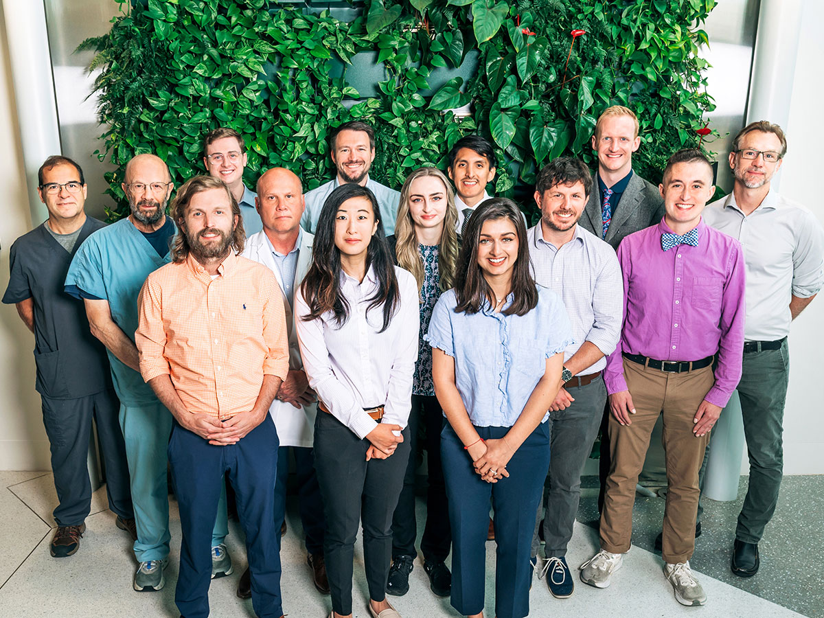 More than a dozen members of the IC-ID team post for a group picture in the lobby of the McCallum building on UAB's campus