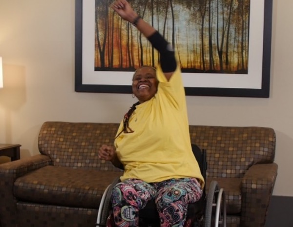 Black woman in wheelchair lifting weights.