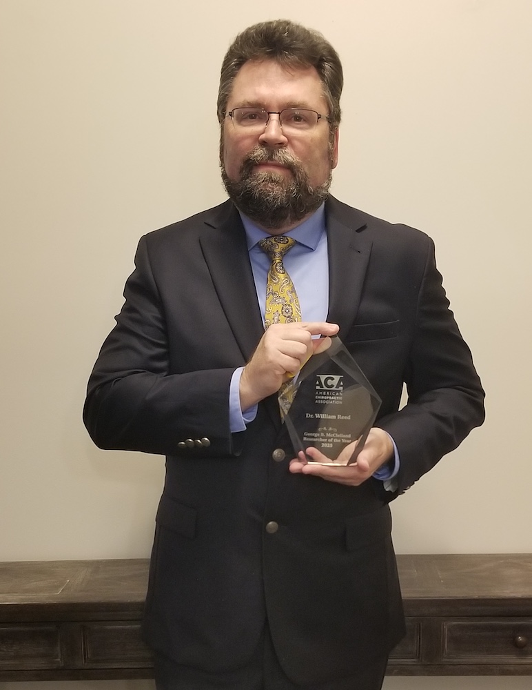 William Reed poses with his researcher of they year award.