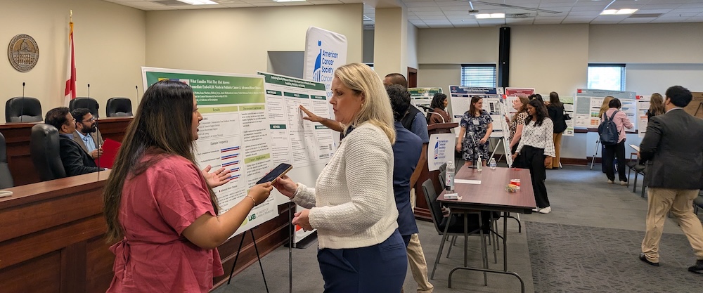 Students presenting research posters to legislature and staffers.