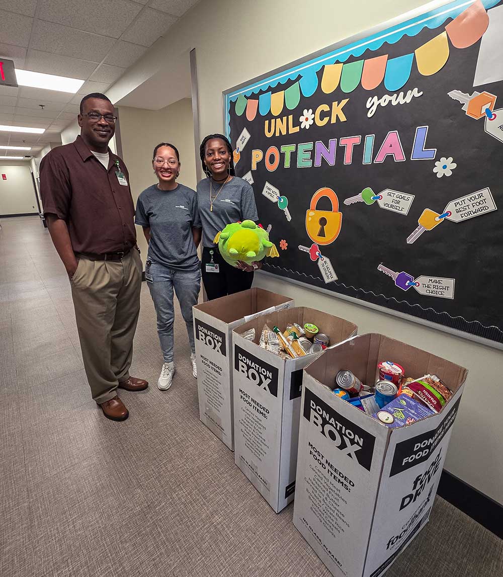 MSBHS students standing in the hallway next to a donation box.