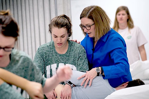 Student evaluating patient's spine.