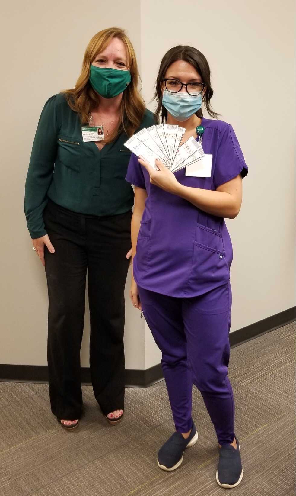 Student Pamela Hayes receives 10 tickets to the UAB vs. Georgia football game Sept.8, 2021; Assistant Vice President Dr. Kennedy stands at Pamela's side