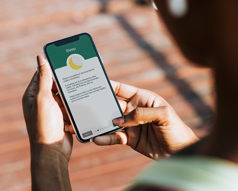 Student holding phone with B Well UAB app displayed